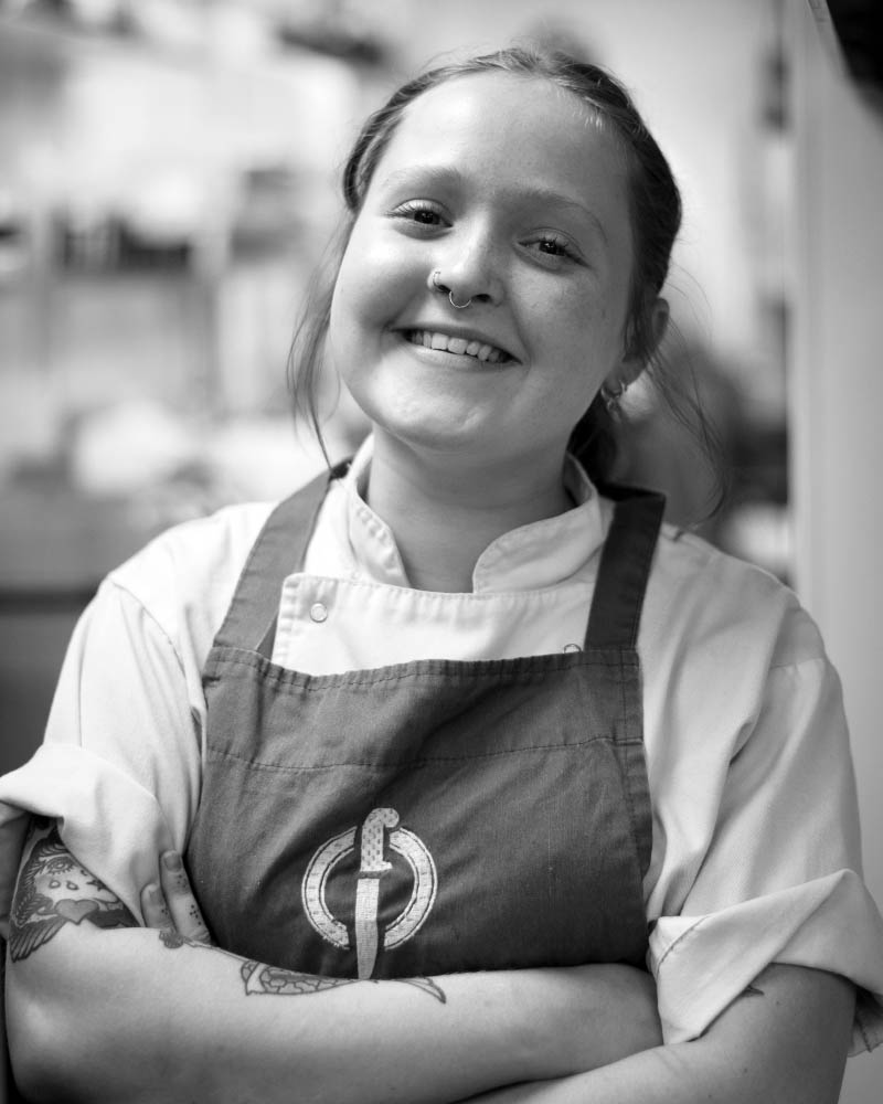About Fletcher's Restaurant - Meet Becky, one of our talented chefs, smiling happily in our kitchen as she prepares delicious dishes for our guests.