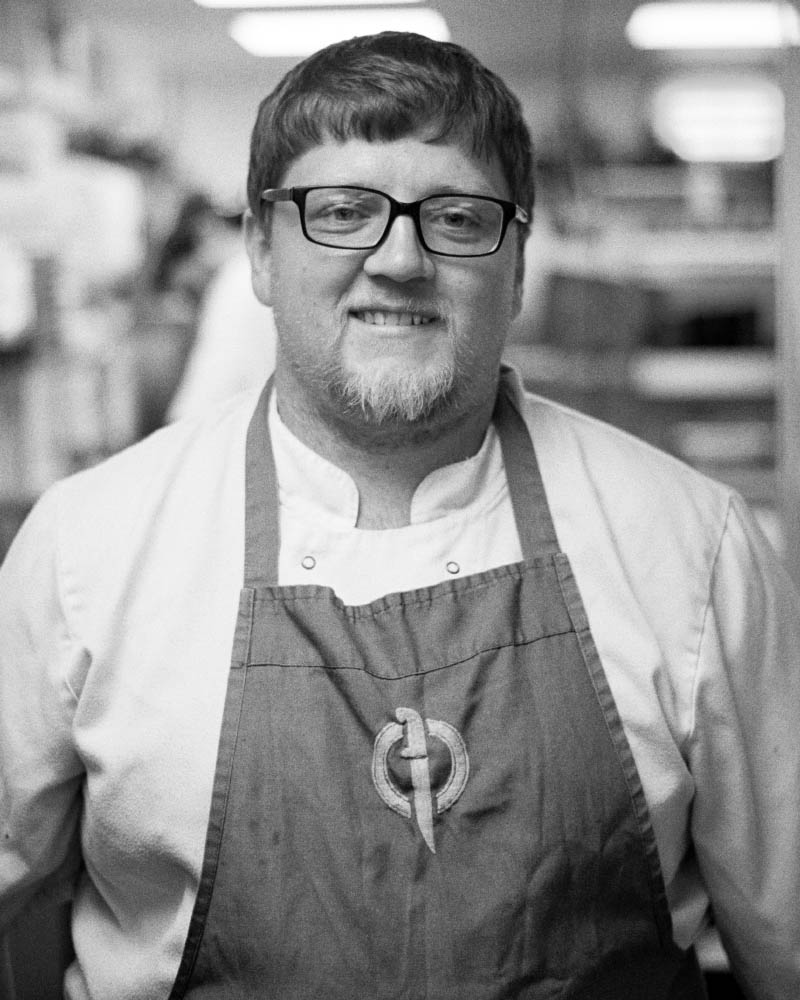 Meet Jimmy, one of our skilled chefs at Fletcher's Restaurant, standing in the kitchen where he prepares exceptional meals for our diners.